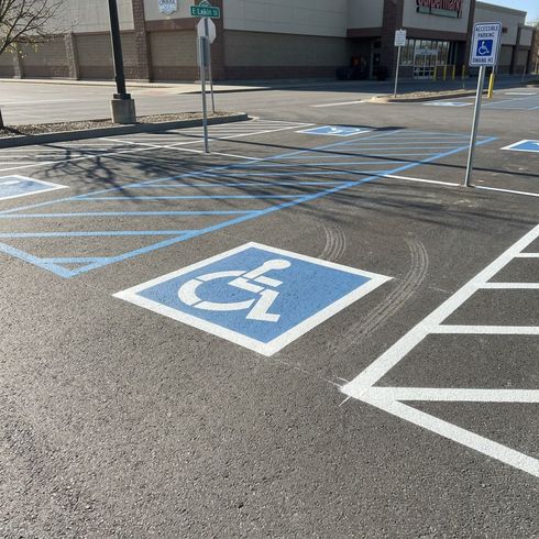 Professional parking lot striping at a gas station with clear yellow lines and numbered spaces
