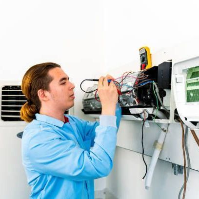 A man in a blue shirt is working on a machine.