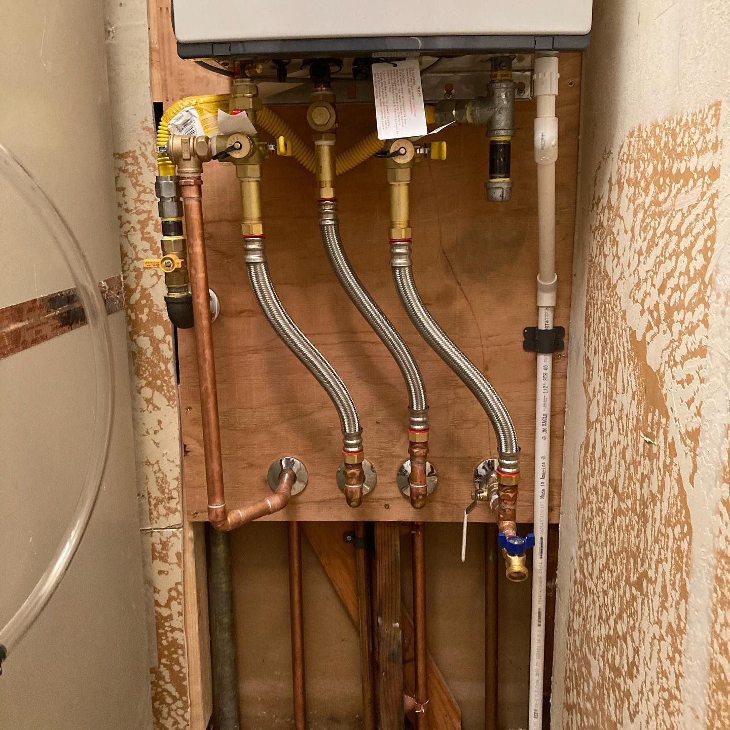 a boiler is being installed in a wall with copper pipes