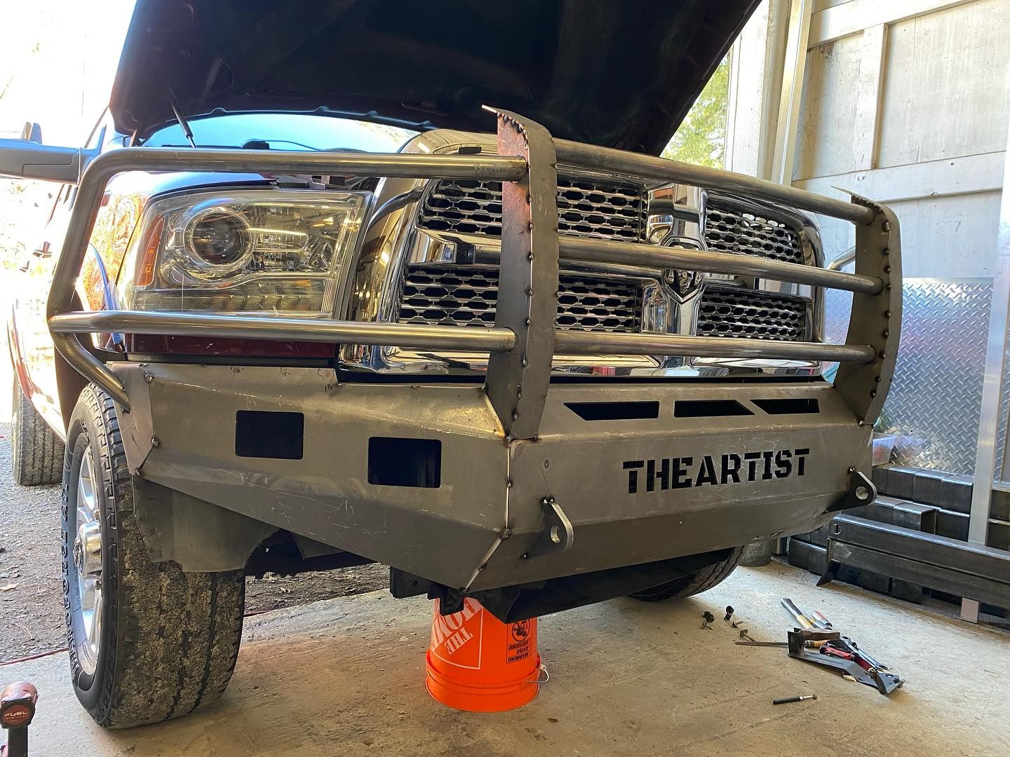 a truck with the hood up is sitting on a jack .