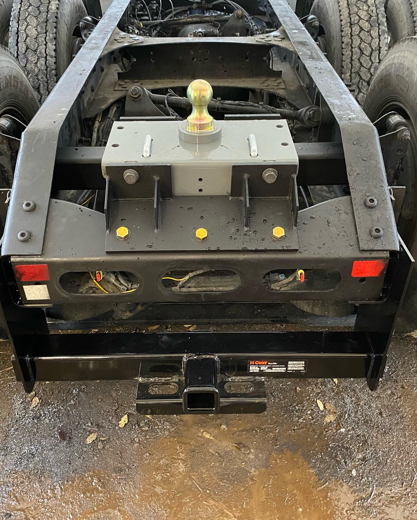 the back of a semi truck with a trailer hitch attached to it .