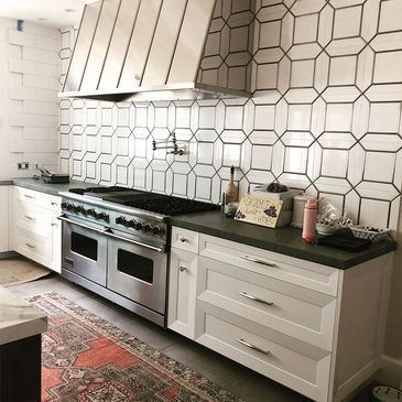 A kitchen with stainless steel appliances and white cabinets.