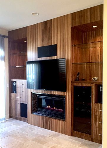 A living room with a fireplace and a flat screen tv on the wall.