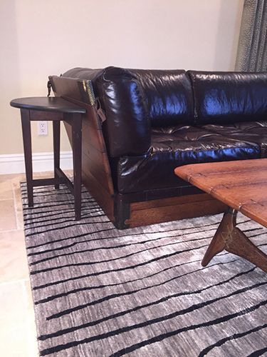 A living room with a couch , coffee table , and rug.
