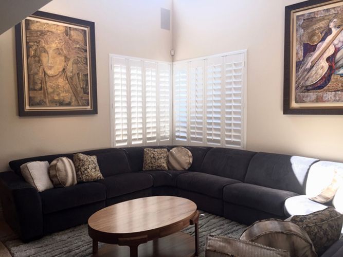 A living room with a large sectional couch and a coffee table.