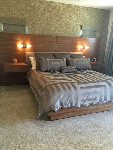 A bedroom with a large bed and a wooden headboard.
