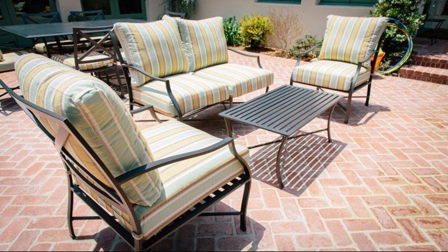A patio with a couch, chairs, and a table.