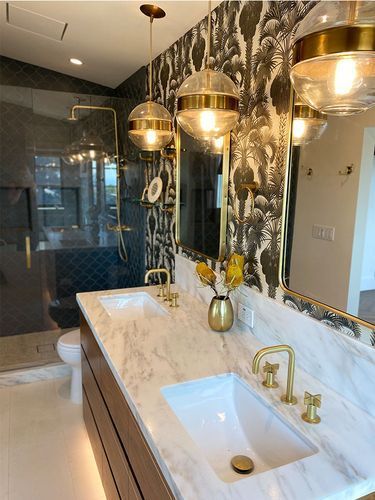 A bathroom with two sinks , a toilet and a shower.
