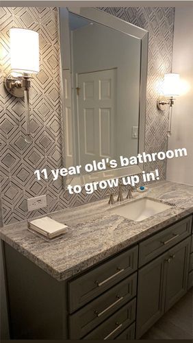 A bathroom with a sink, mirror and cabinets.