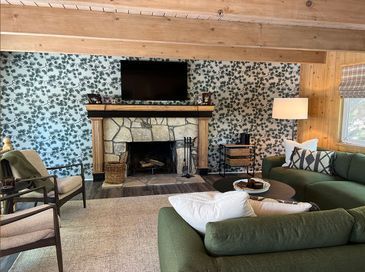 A living room with a couch, chairs, a fireplace, and a television.