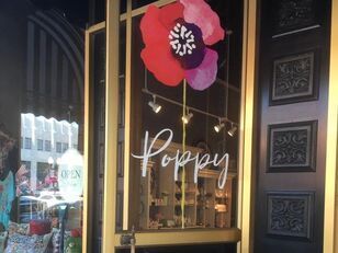 A store front with a large poppy in the window.