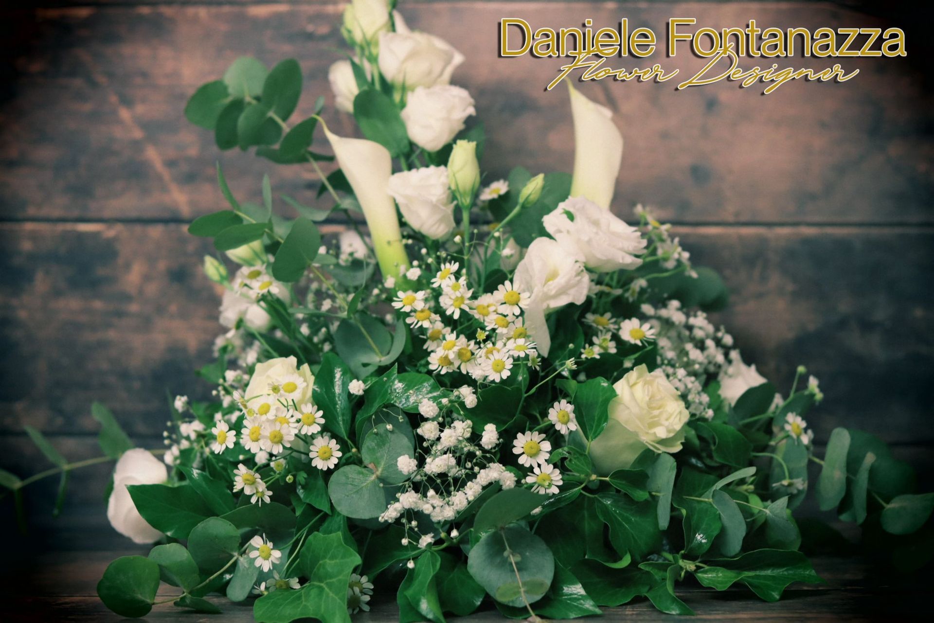 Composizione floreale bianca e verde con calle, lisianthus e foglie di eucalipto.