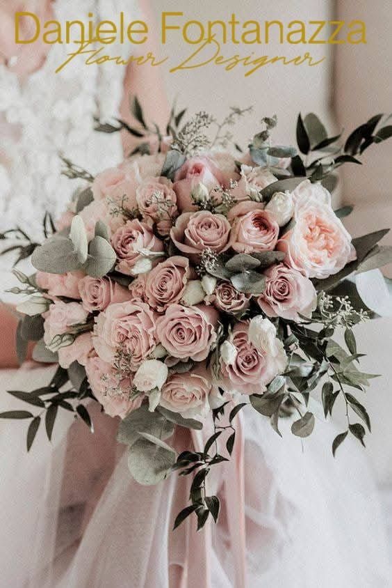 Una persona che tiene in mano un mazzo di rose rosa e bianche e verde, su sfondo sfocato.