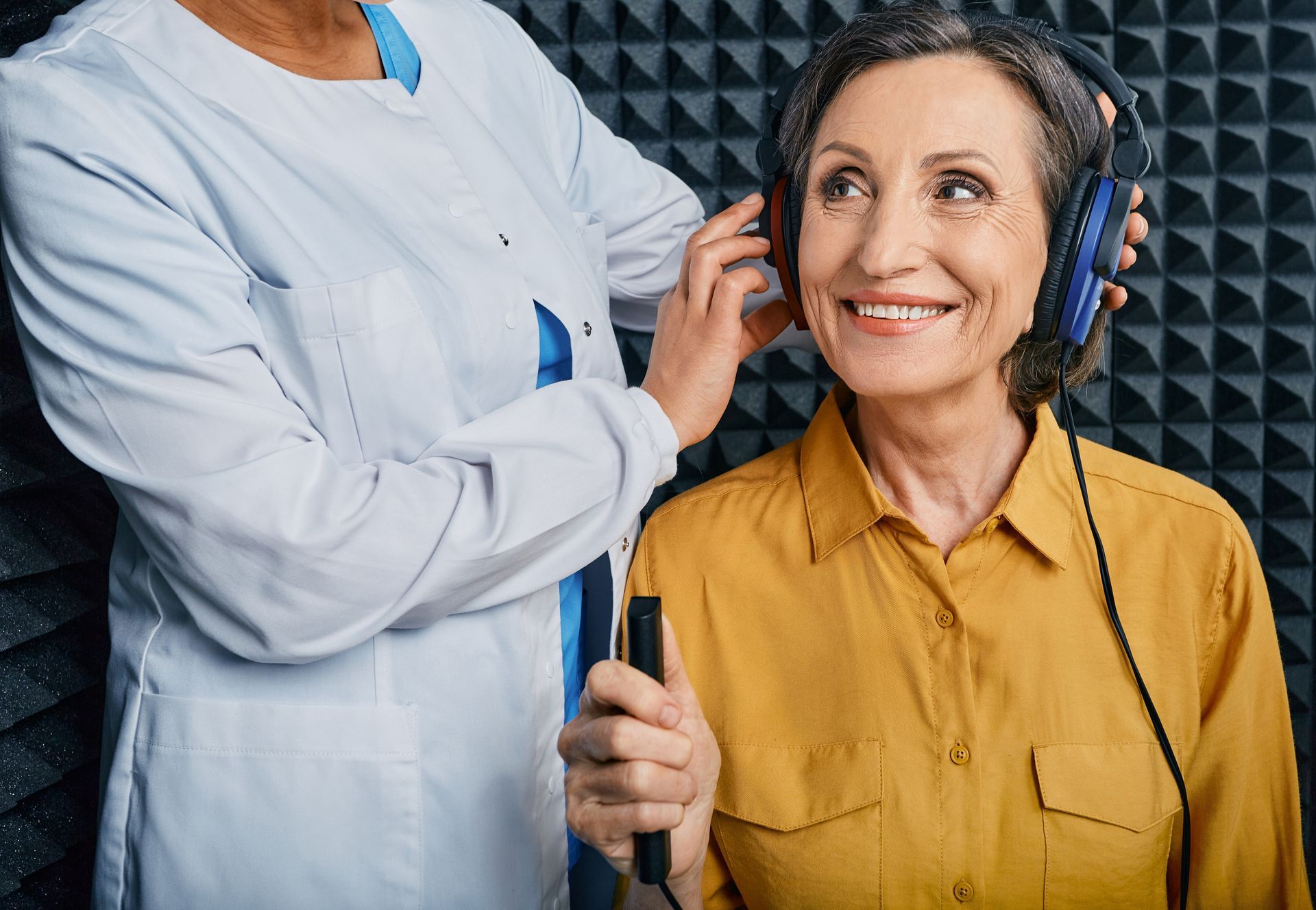 An audiologist adjusting headphones during a hearing test.