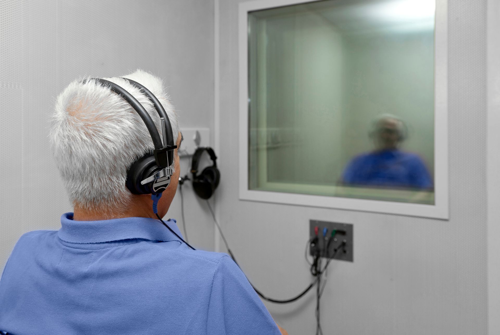 A senior man is getting a hearing exam. A senior man is getting a hearing exam.