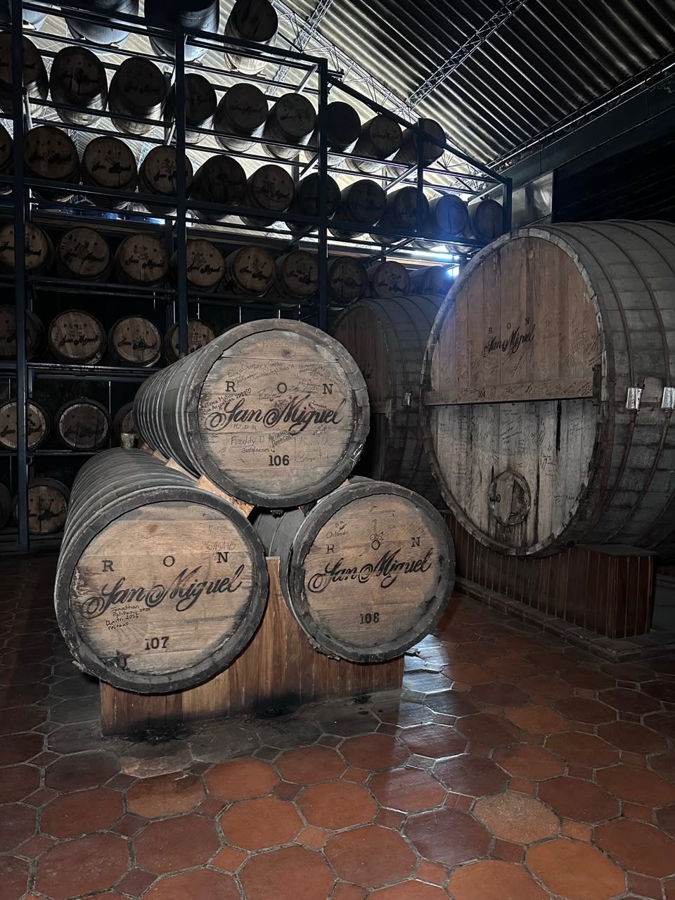 A man and a woman are standing next to a large wooden barrel.