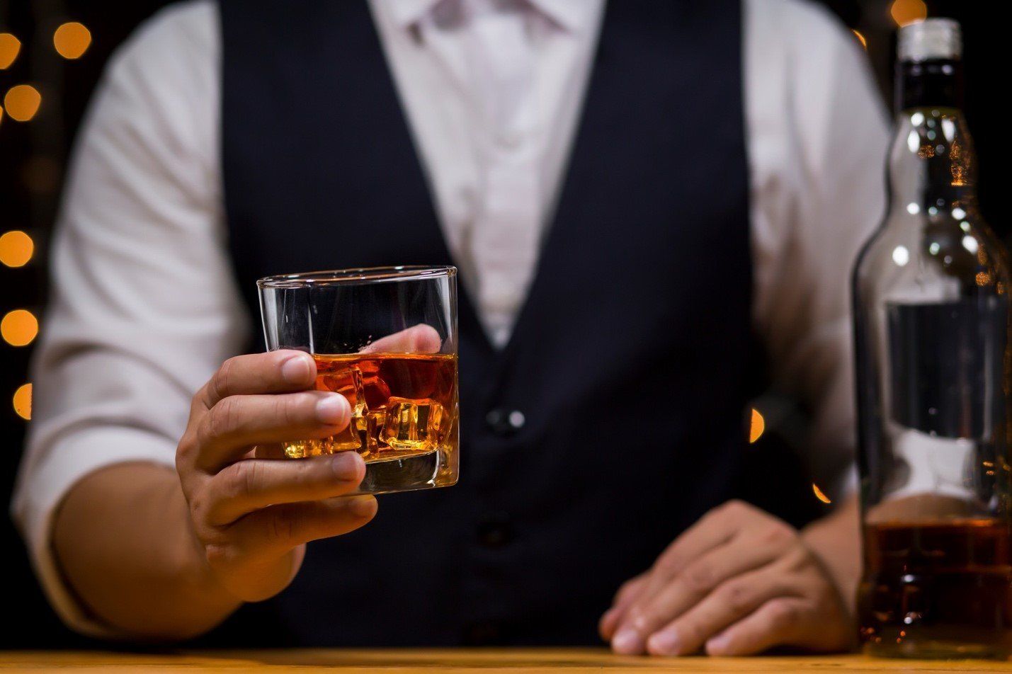 Barman sosteniendo un vaso de Ron