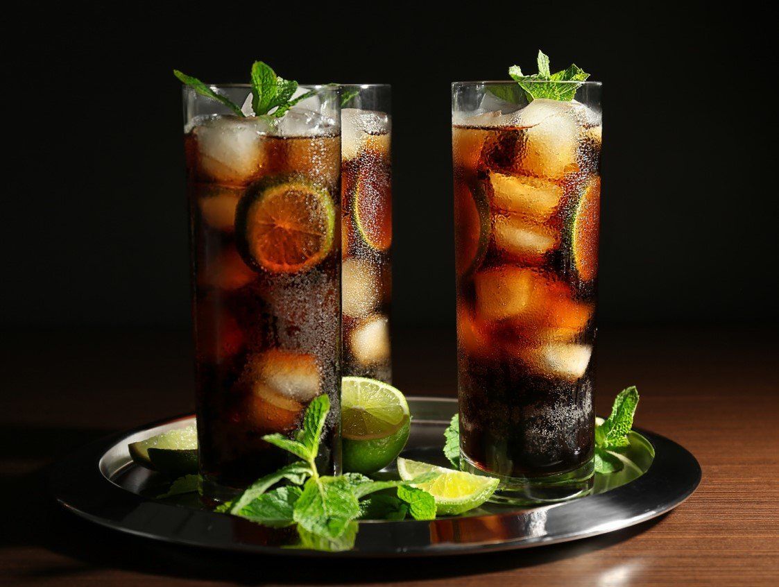 Bandeja exhibiendo 3 vasos de Ron con Cola decorados con hojas de menta