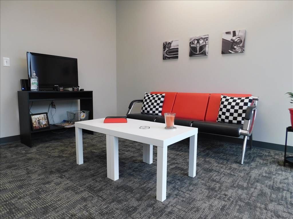 A waiting room with a couch , table and television