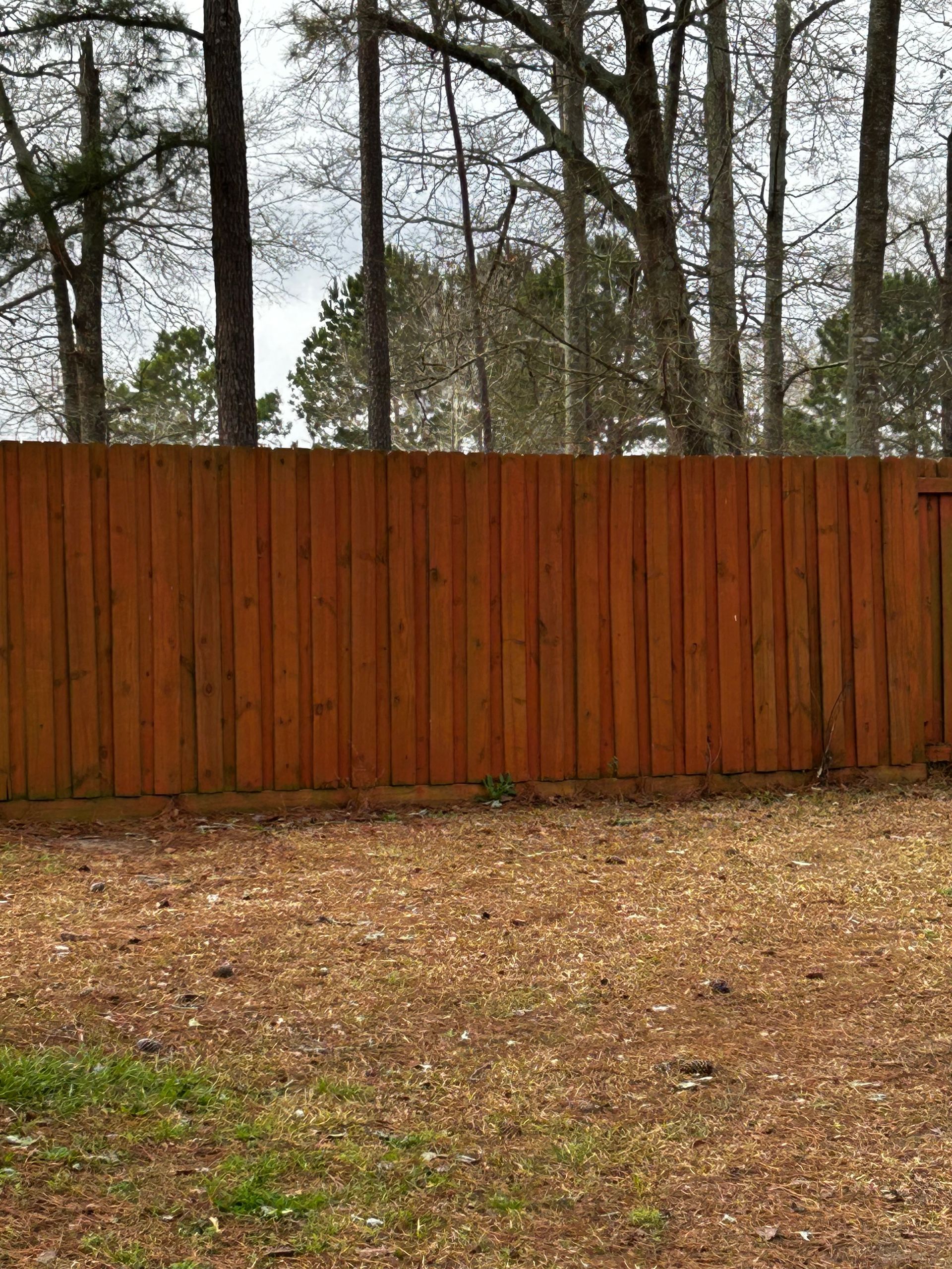 Three people building a wooden fence outdoors on a sunny day. Three people building a wooden fence outdoors on a sunny day.