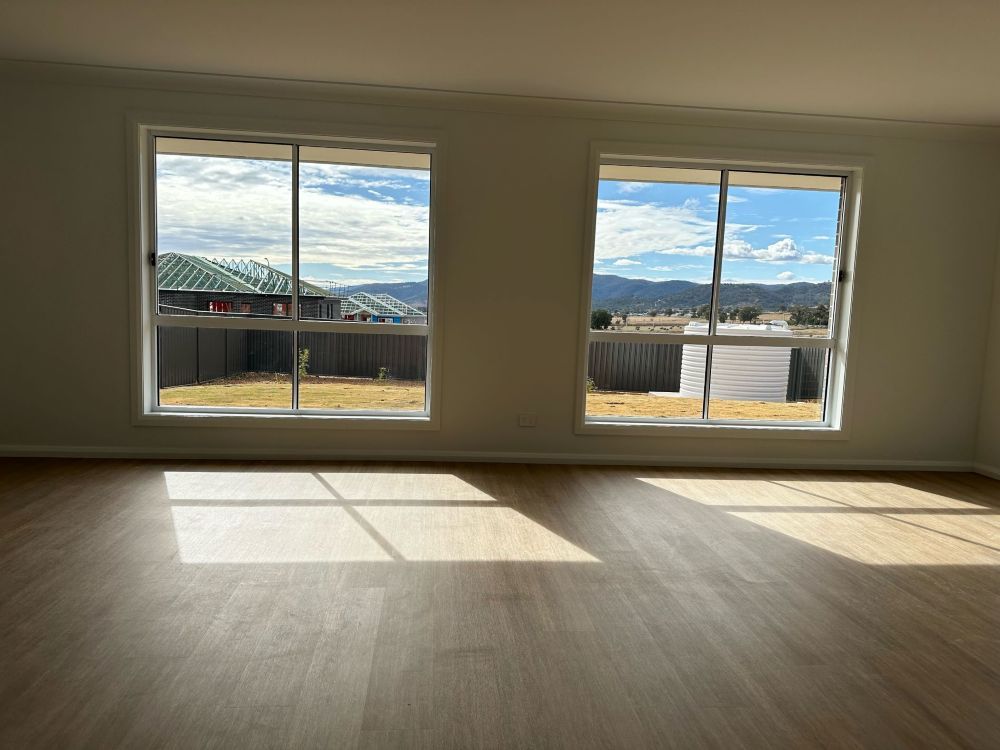 An Empty Living Room With Two Windows And A Wooden Floor — A1 Cleaner Carpets N Homecare In Atherton, QLD