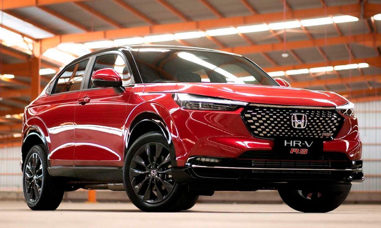 SUV Honda vermelha em um showroom, vista de frente à esquerda, com pintura vermelha brilhante e rodas pretas.