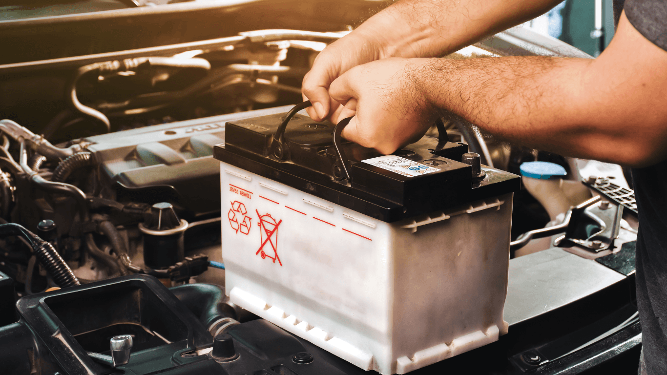 A mechanic replacing a car battery in Toledo, OH
