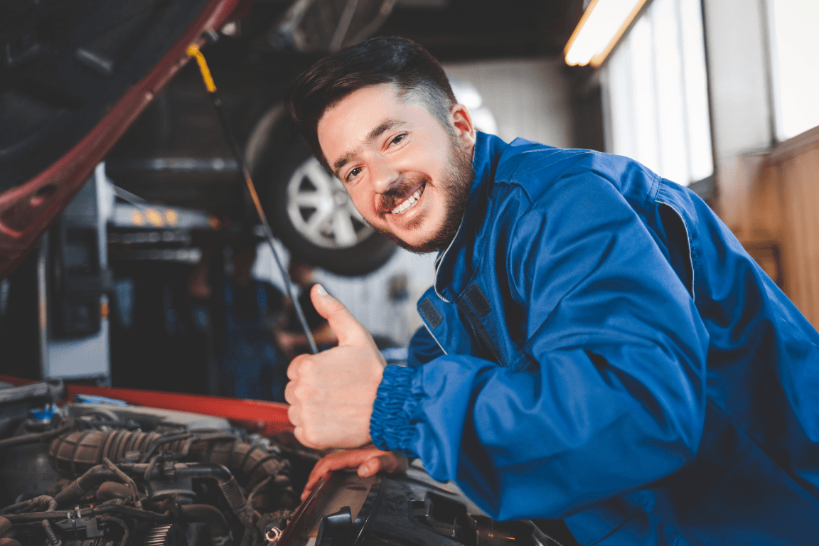 A happy mechanic working on a vehicle