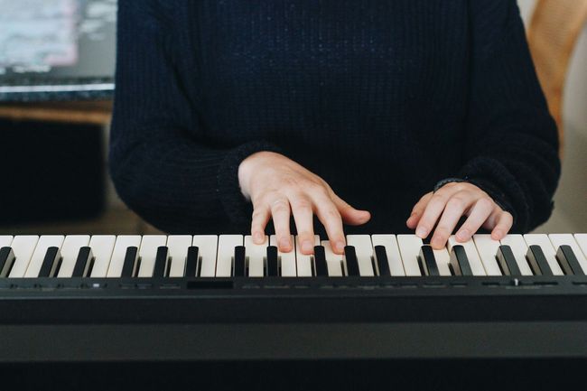 Adult playing a digital piano.