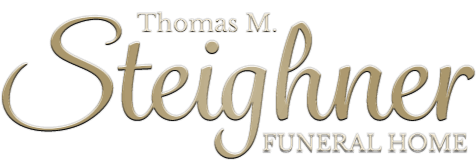Logo for Thomas M. Steighner Funeral Home, with a cursive name in gold and “FUNERAL HOME” in gray.