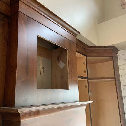 A wooden cabinet with a mirror on top of it