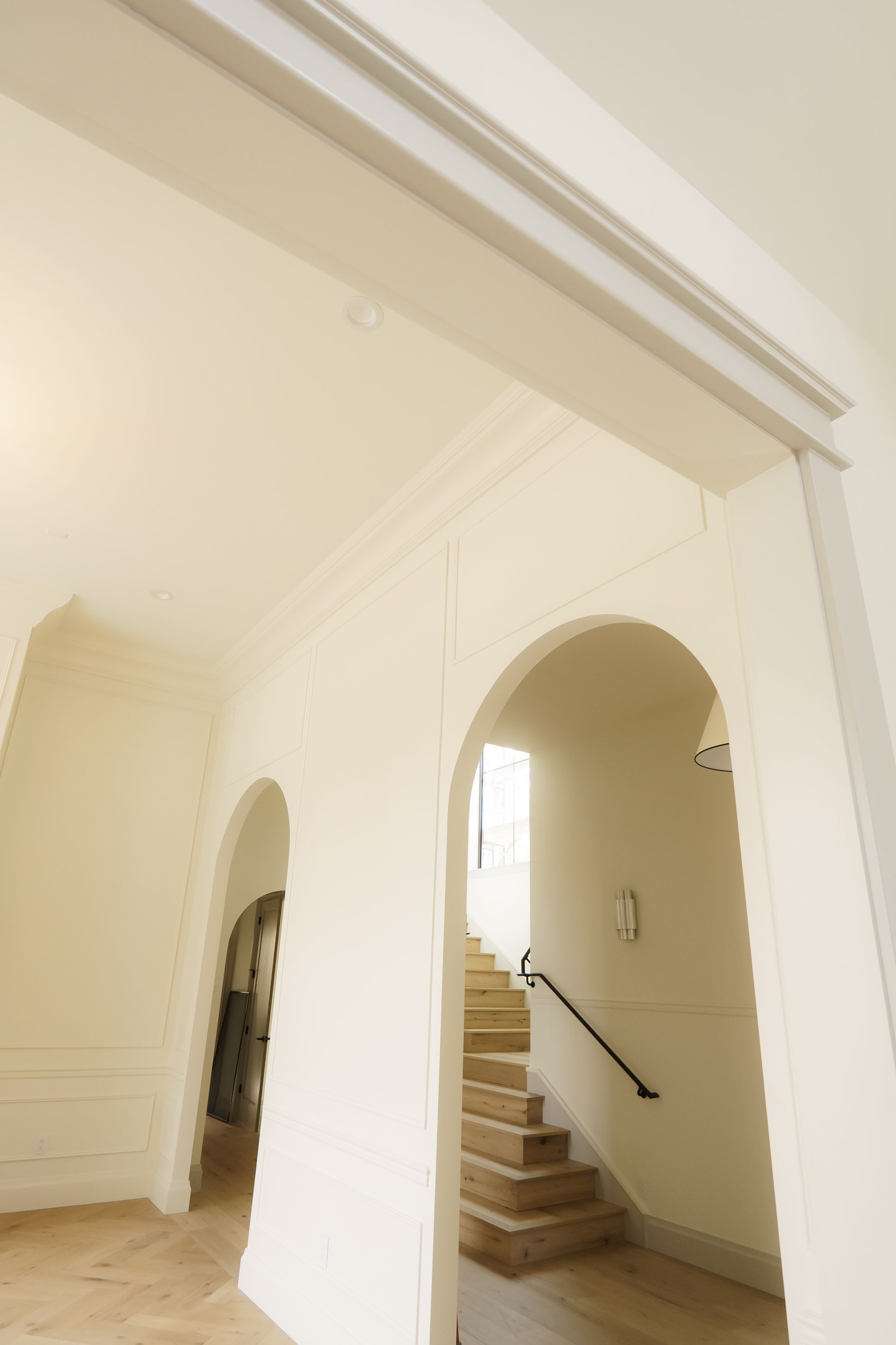 A hallway with arches and stairs in the background