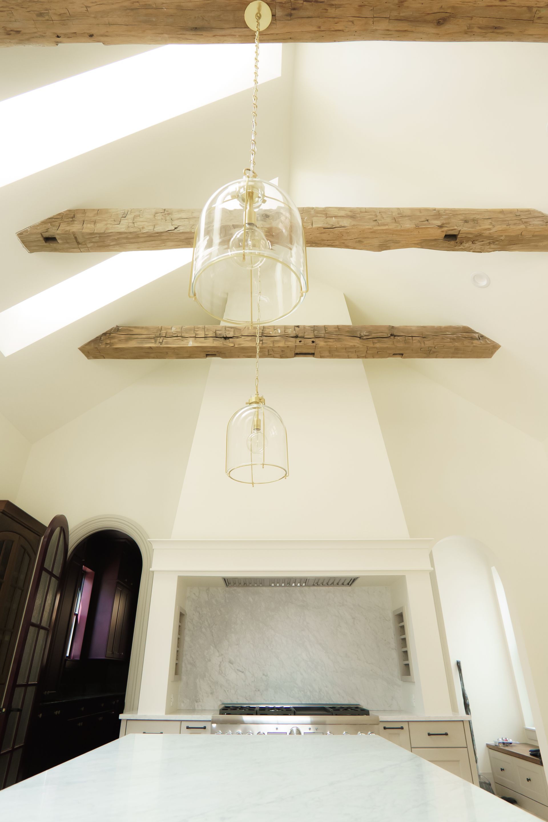 A kitchen with a stove and a ceiling with wooden beams.