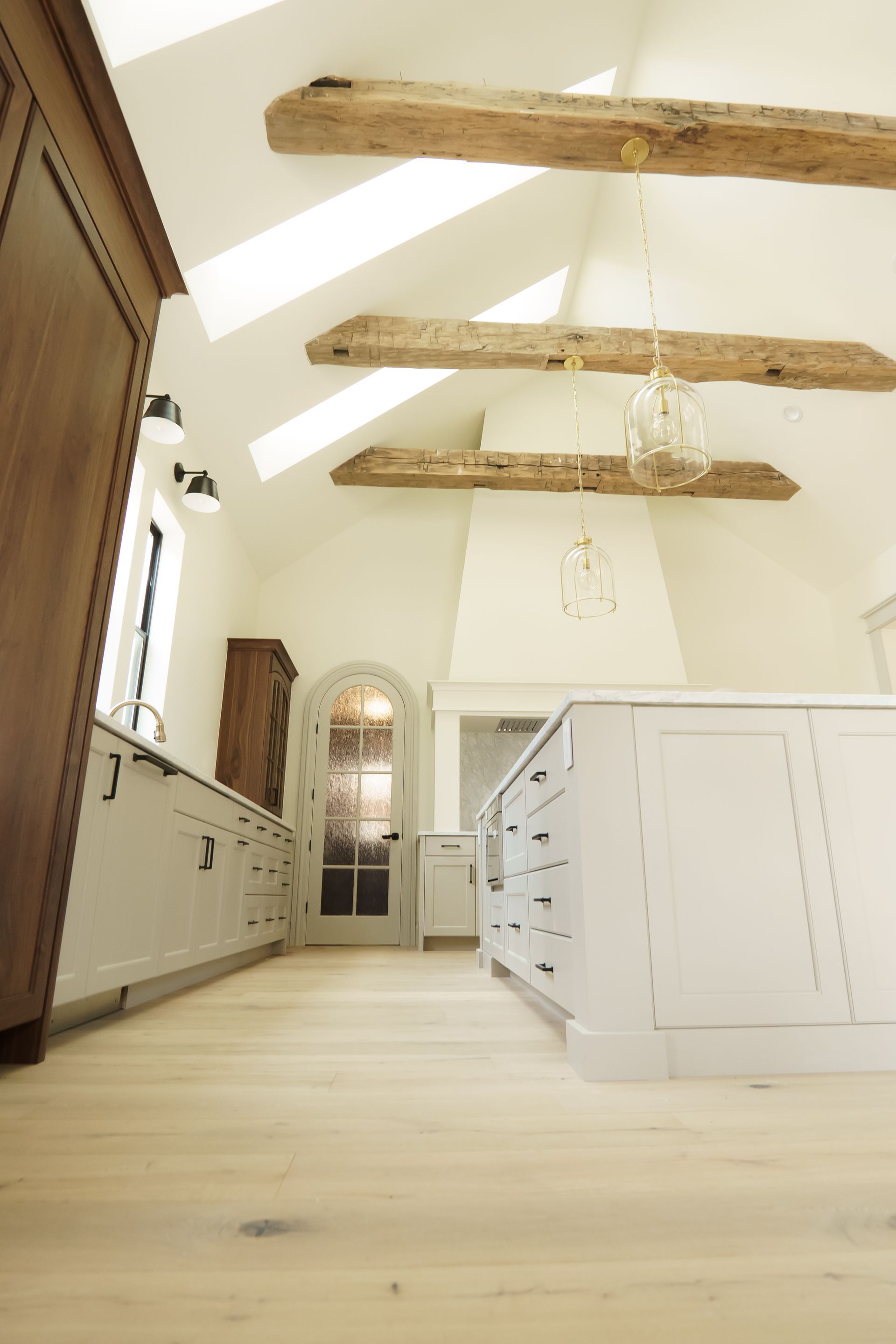 A kitchen with white cabinets and wooden beams on the ceiling.