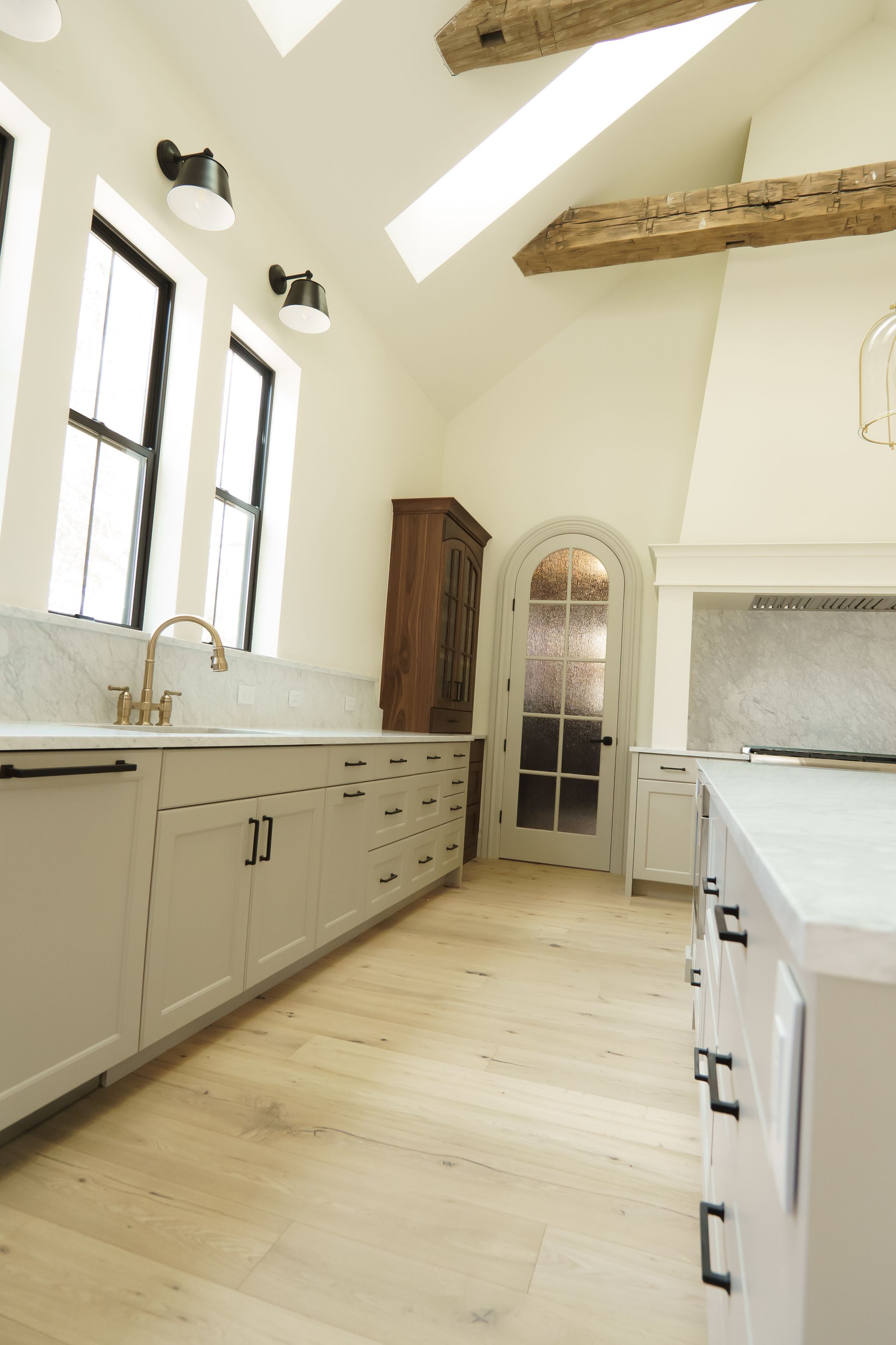 A kitchen with white cabinets and wooden floors
