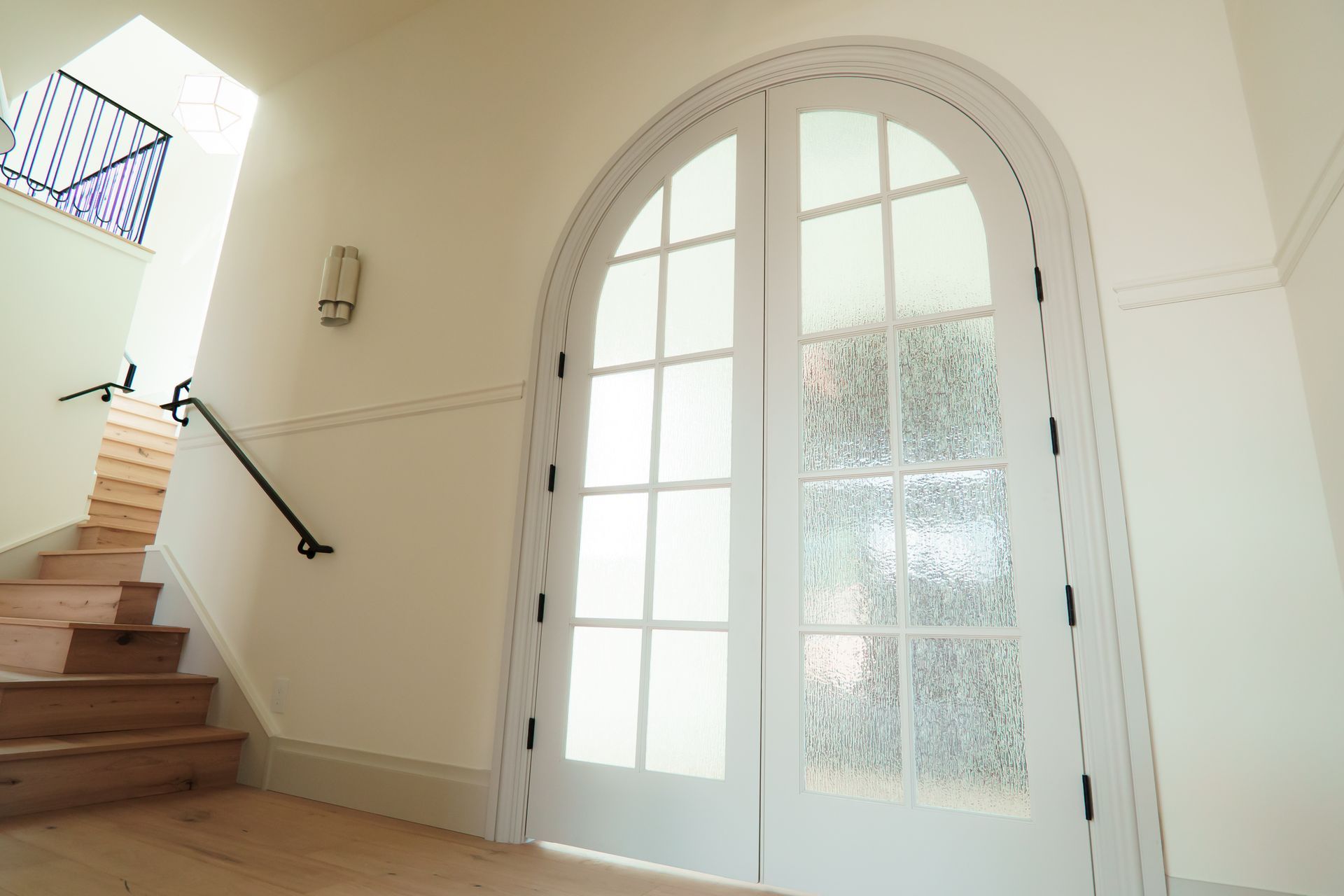 A hallway with stairs and a white door