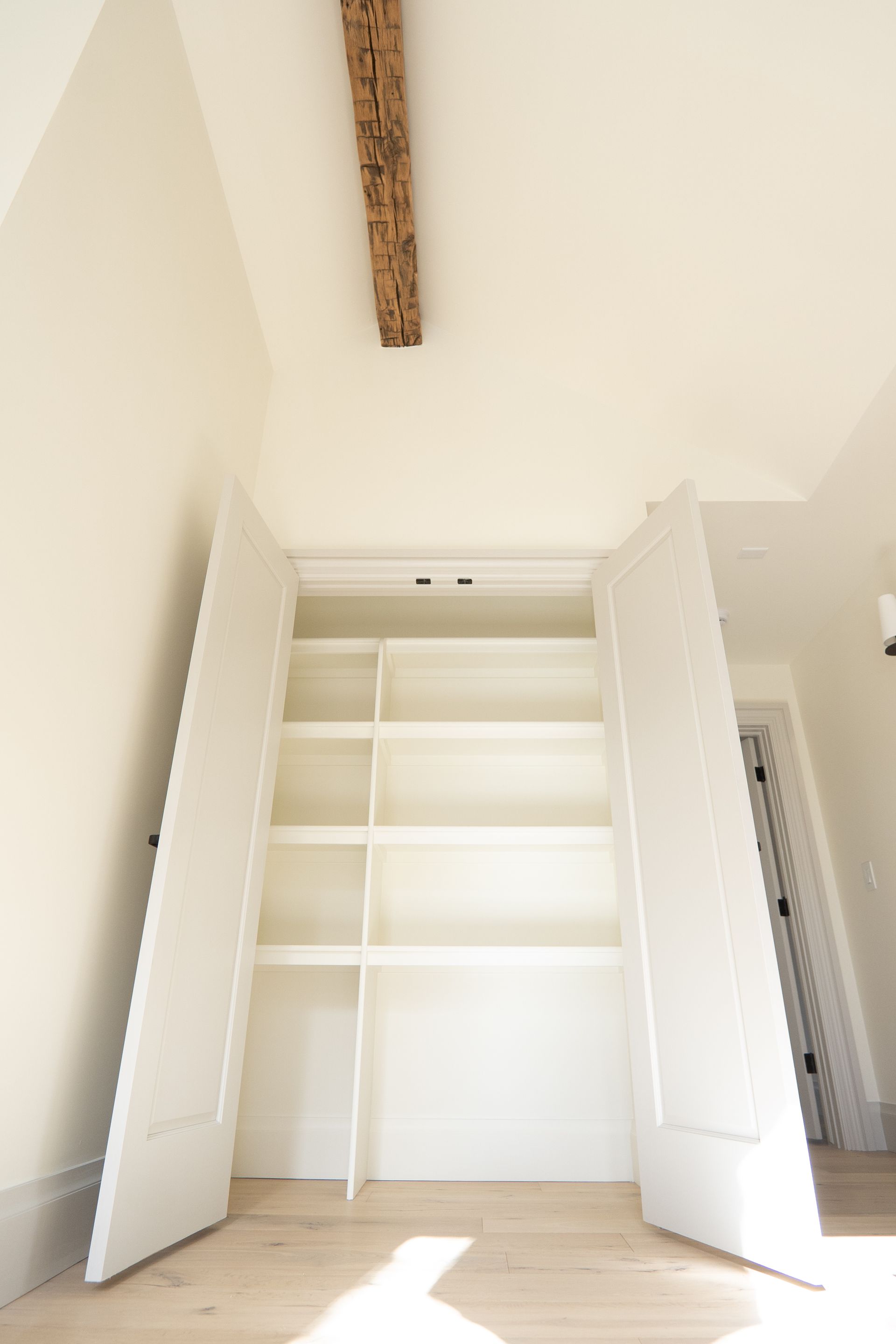 A closet with a wooden beam hanging from the ceiling