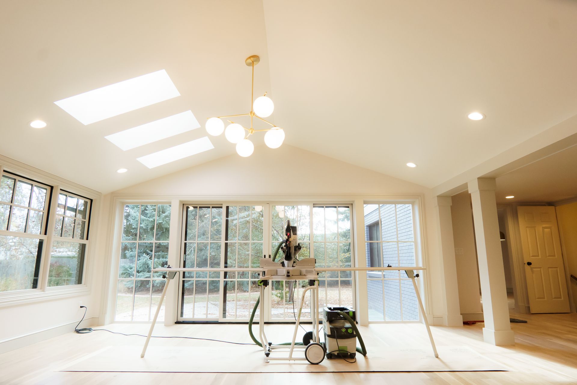 A large room with a lot of windows and a vacuum cleaner on the floor.