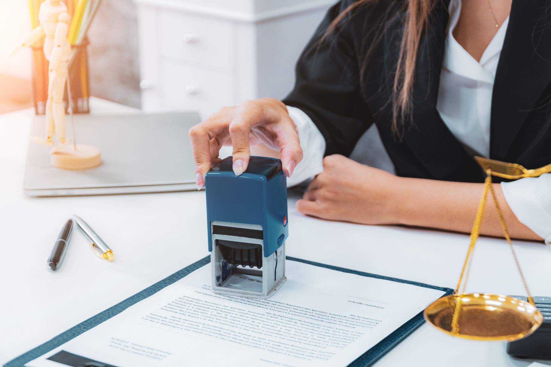 A woman is putting a stamp on a piece of paper.
