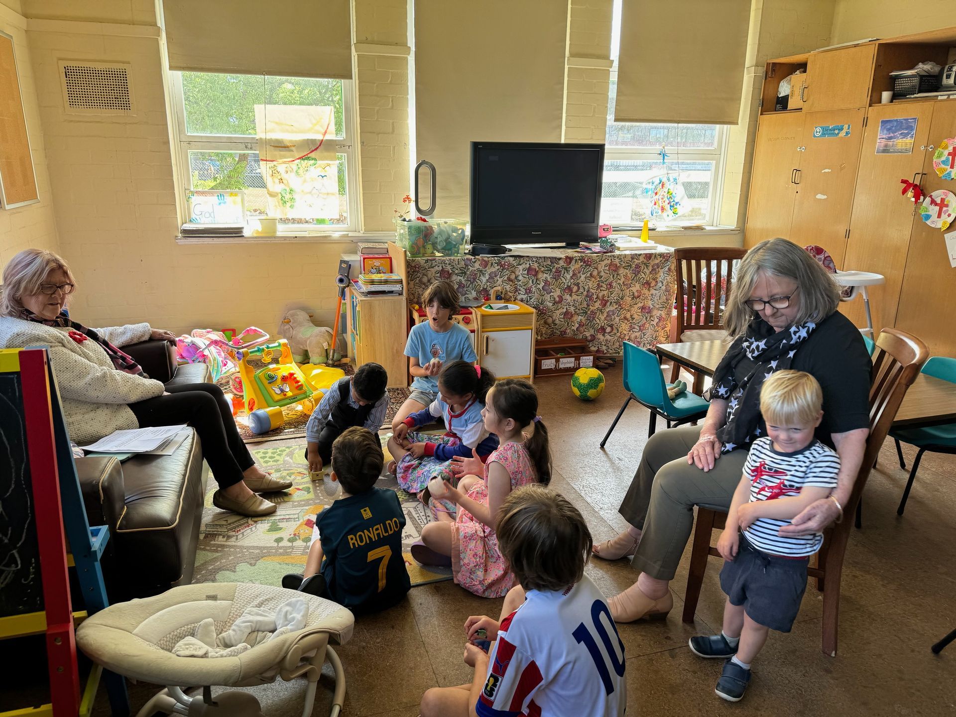 A group of children are sitting on the floor in a room.
