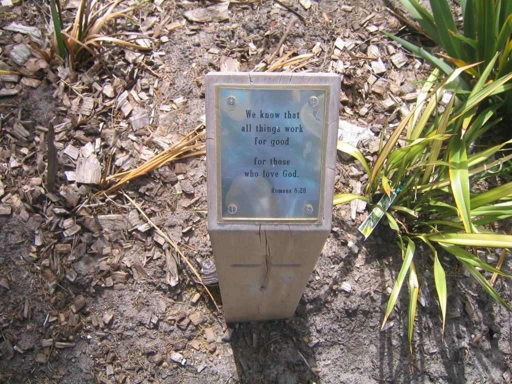 A wooden post with a bible verse on it.