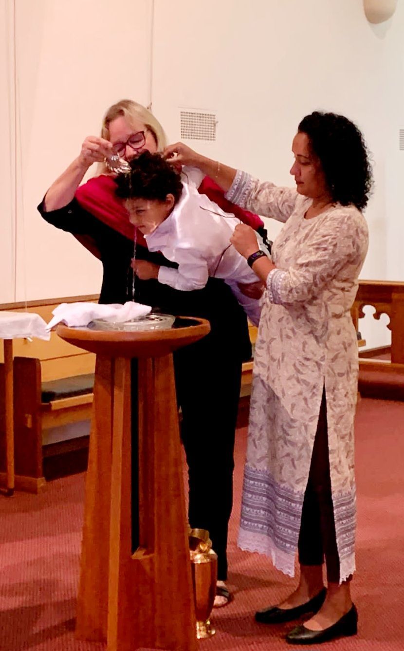 Child being baptised with water