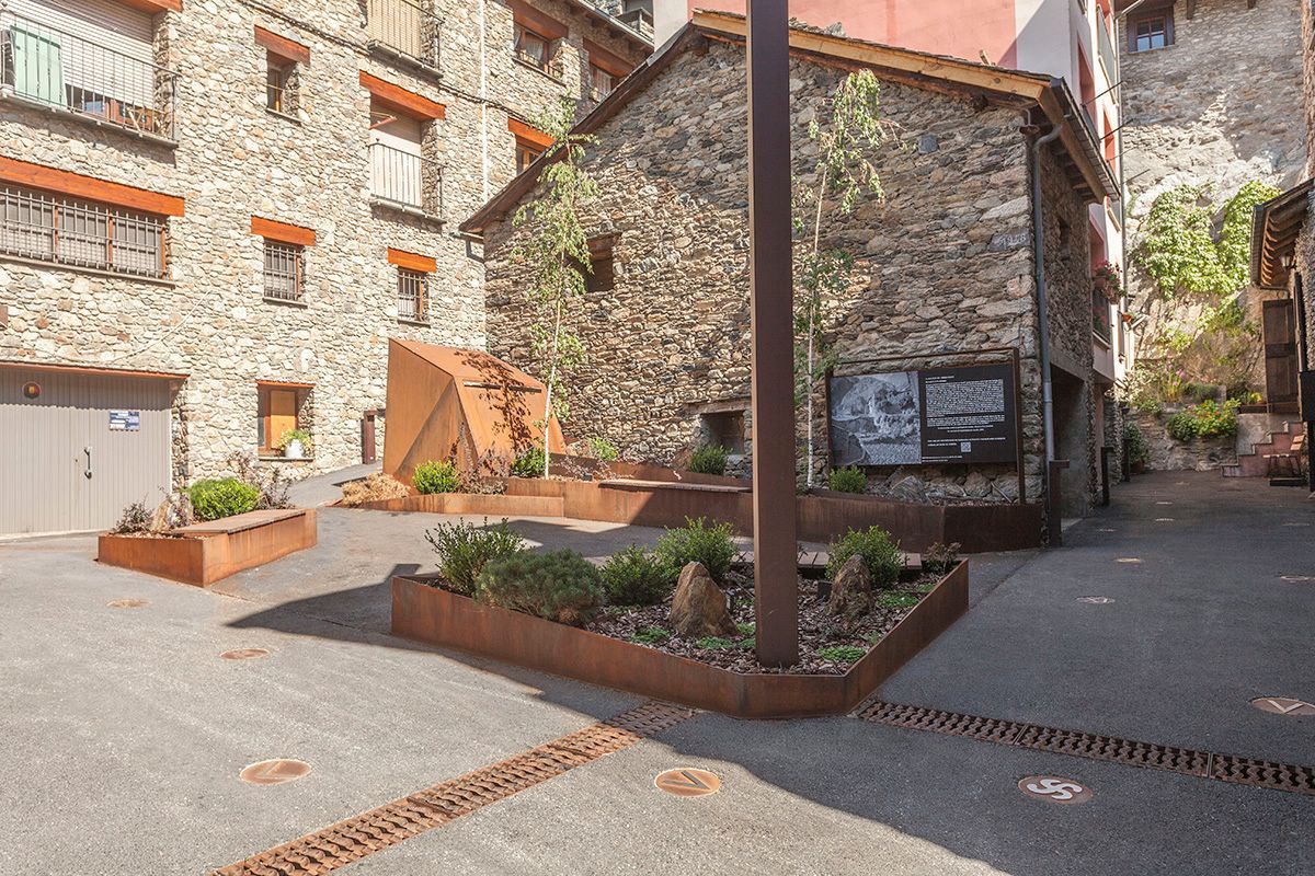 Un edificio de piedra con un letrero al costado. Emfasi Estudi
