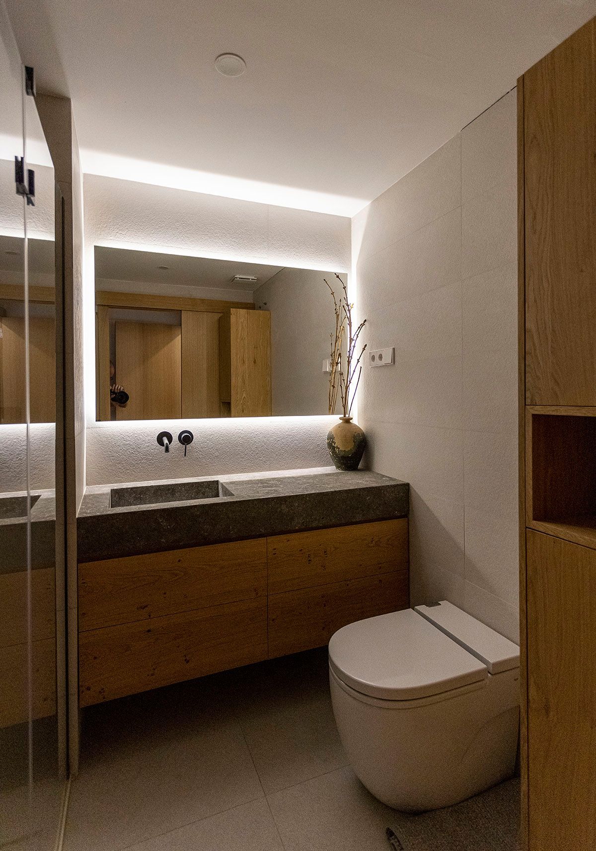 Un baño con inodoro, lavabo y espejo. Fotografia Emfasi Estudi Andorra y Barcelona.