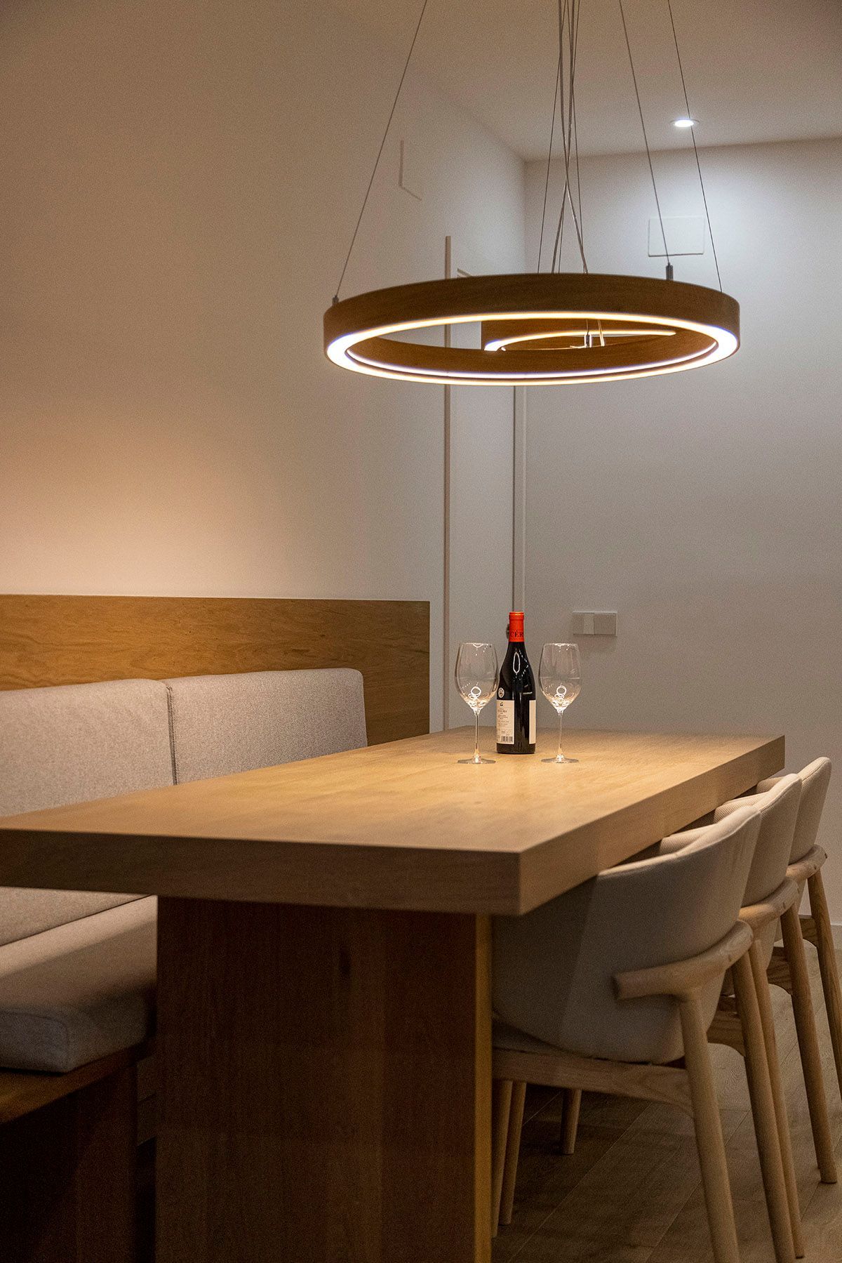 Una mesa de comedor con una botella de vino y dos copas encima. Fotografia Emfasi Estudi Andorra.