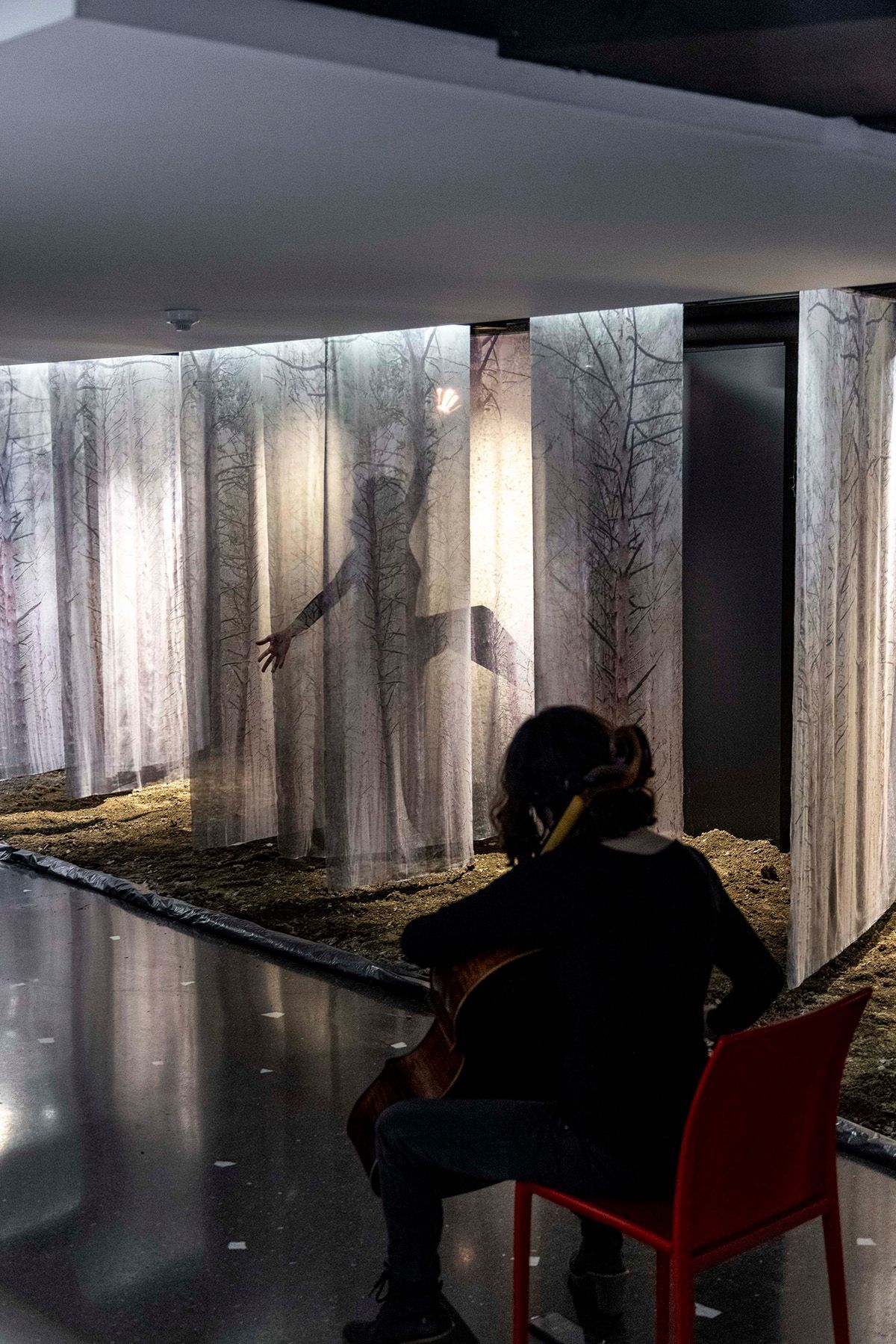 Una mujer está sentada en una silla tocando el violín. Fotografia Emfasi Estudi Andorra y Barcelona.