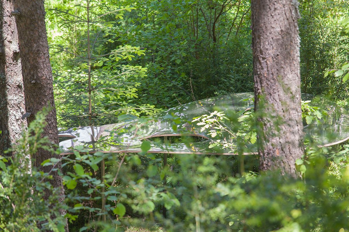 Fotografia Emfasi Estudi Andorra. Una obra artística en medio de un bosque rodeado de árboles.