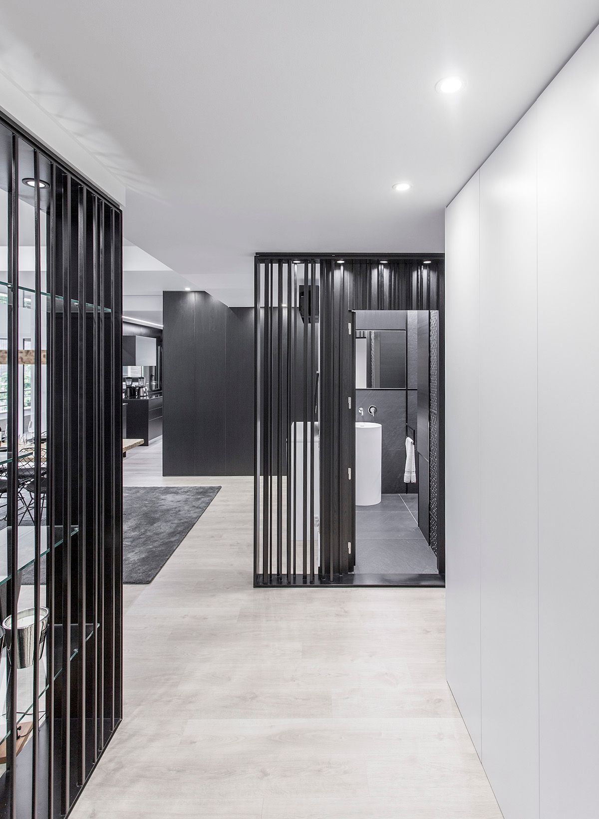 Un pasillo con puerta corredera de cristal que conduce al baño. Fotografia Emfasi Estudi Andorra y Barcelona.