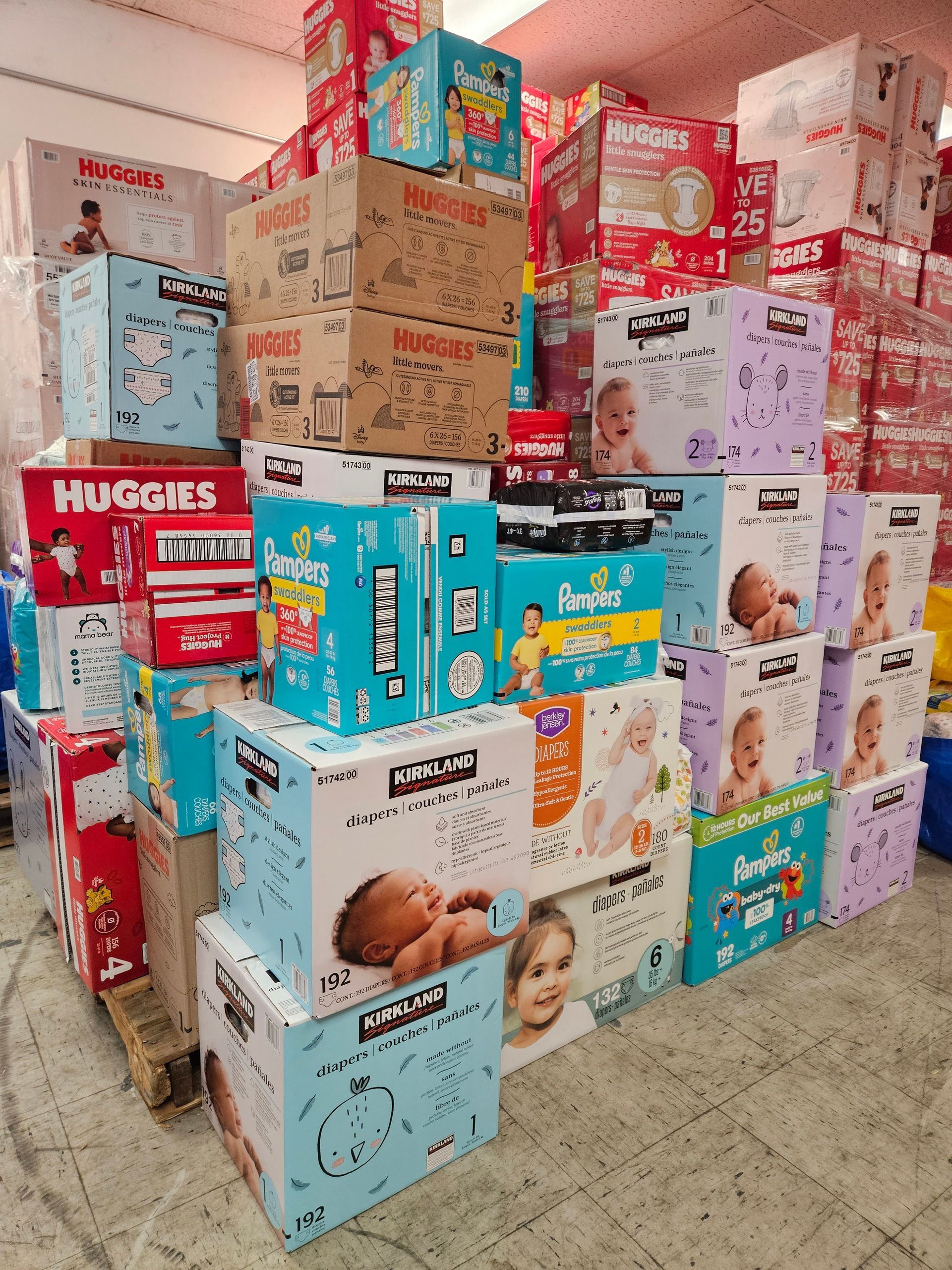 Stacked boxes of baby diapers and wipes in various colors in a store aisle