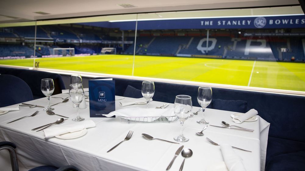 Elegant dining table overlooking a football stadium at night